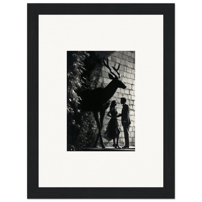 Black and white photograph of a deer’s shadow on a brick wall, with silhouettes of two people beneath it.