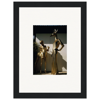 Framed photograph of two golden mannequins in elegant poses.