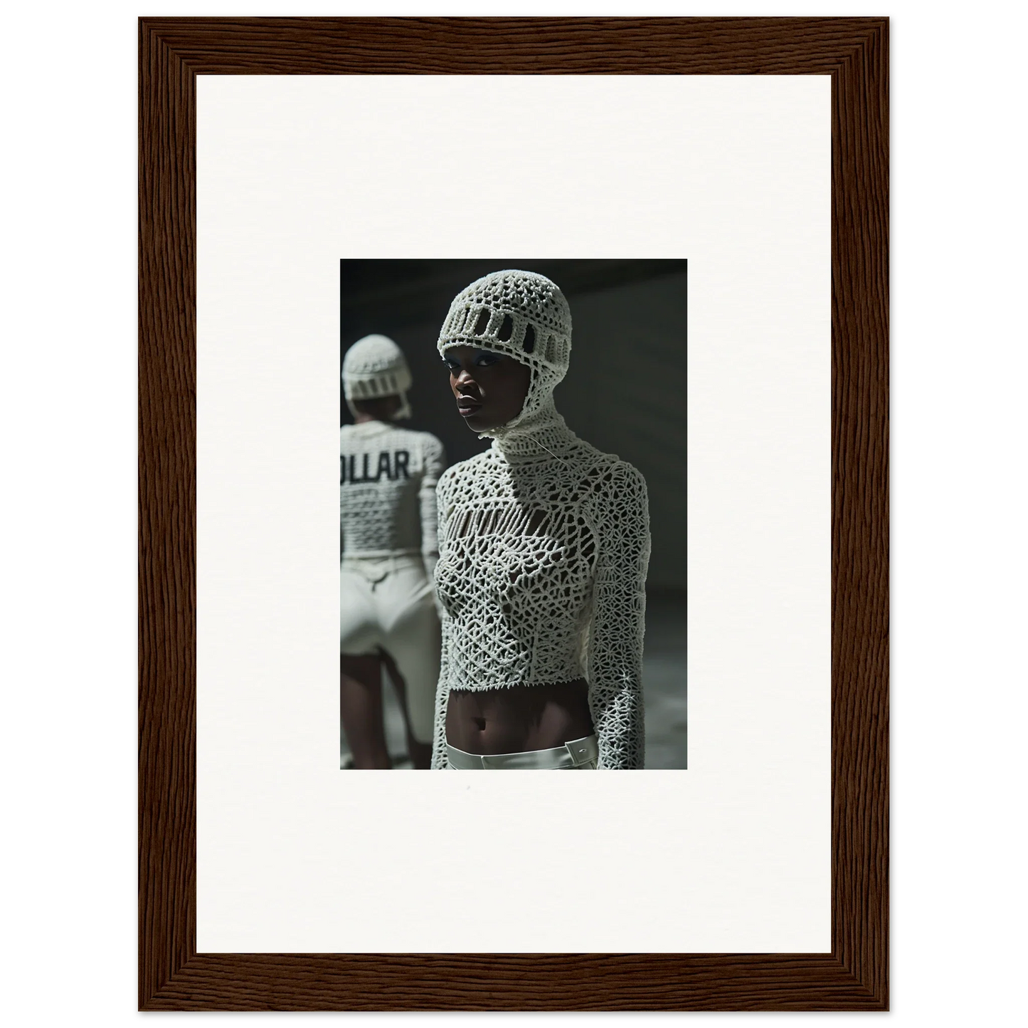 Framed black and white photograph of a person wearing an intricate mesh bodysuit and cap.