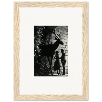 Framed black and white photograph showing silhouettes of a deer and two people against a wall.