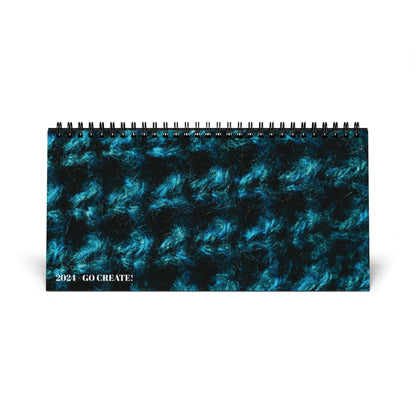 Limited edition Crochet Addicts - 2024 Desktop Calendar with a blue background featuring a beautiful crocheted pattern.