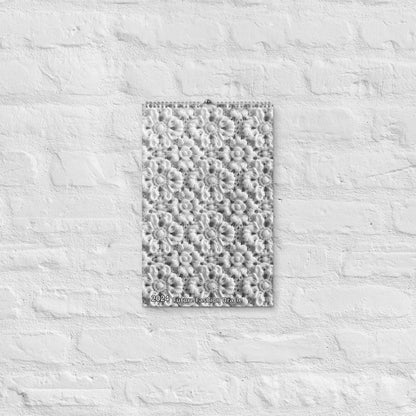 An eco-friendly 2024 Crochet Patterns Wall Calendar: A Year-Round Inspiration for Crochet Enthusiasts is hanging, featuring crochet patterns on a white brick wall.