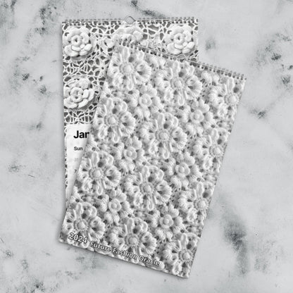 A handmade Crochet Patterns Wall Calendar for the year 2024: A Year-Round Inspiration for Crochet Enthusiasts on a marble surface.