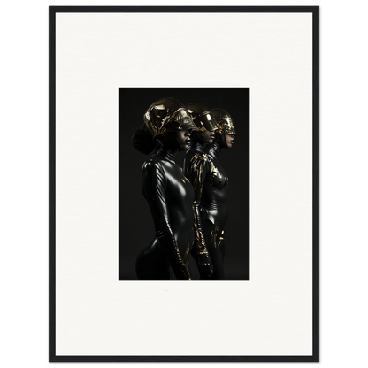 Black and white photograph of metallic-looking human figures in dramatic poses, framed in a simple black frame.