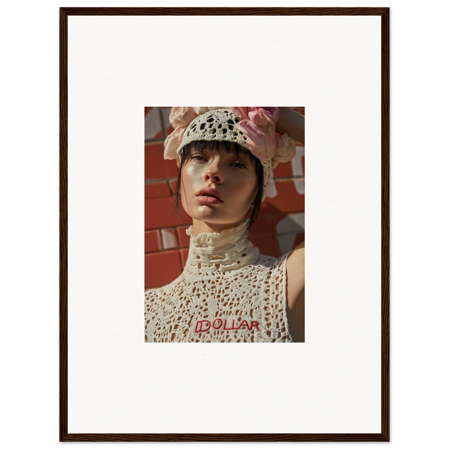 Framed photograph of a person wearing a white crocheted hat and top with red text.