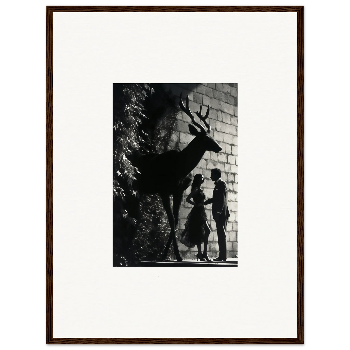 Black and white photograph showing silhouettes of a deer and two people against a brick wall.