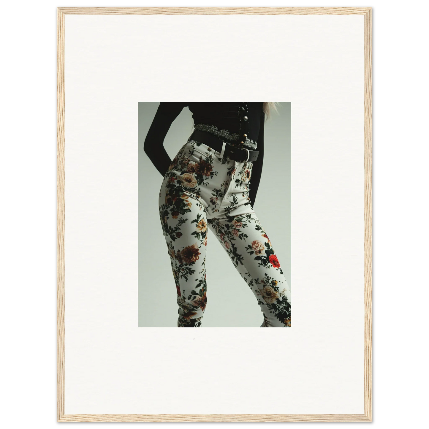 Framed photograph showing a person’s lower body wearing floral-patterned leggings or tights.