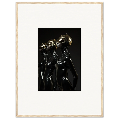 Framed photograph of three figures in shiny black outfits with metallic helmets.