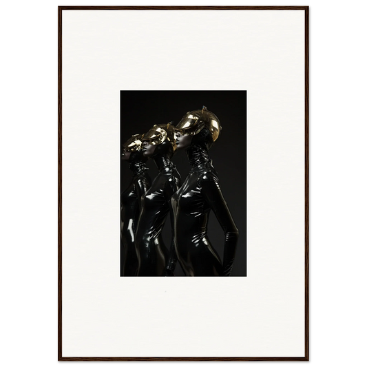 Framed photograph of three figures in shiny, dark outfits with metallic headpieces.