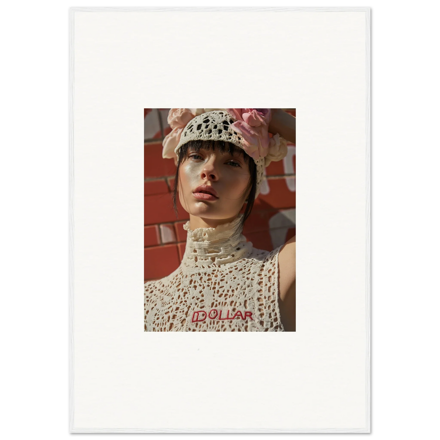 Portrait photograph of a person wearing a white crocheted hat and top against a reddish background.