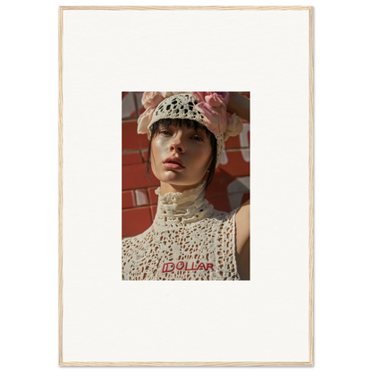 Portrait photograph of a person wearing a white crocheted hat and top with red lettering.