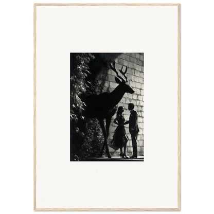 Black and white photograph showing silhouettes of a deer and two people against a brick wall.