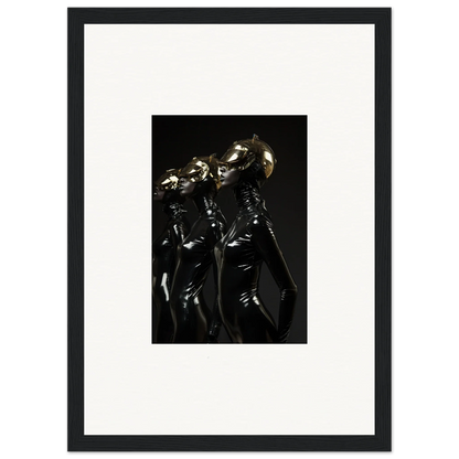 Framed photograph of two figures in shiny black outfits with metallic helmets.