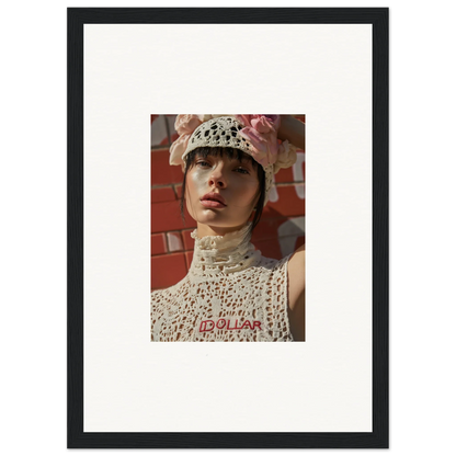 Framed portrait photograph of a person wearing a white crocheted hat and top against a reddish background.