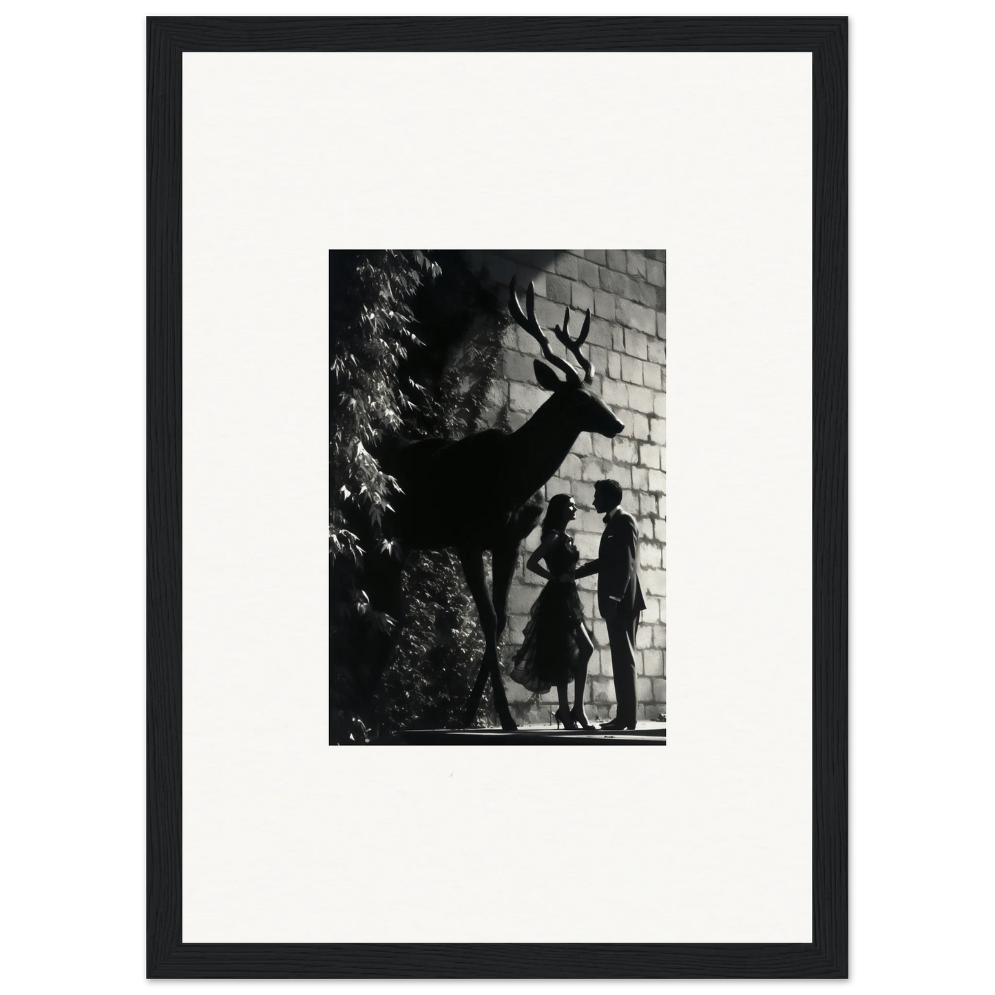 Black and white photograph of a deer silhouette with a couple’s shadows on a wall.