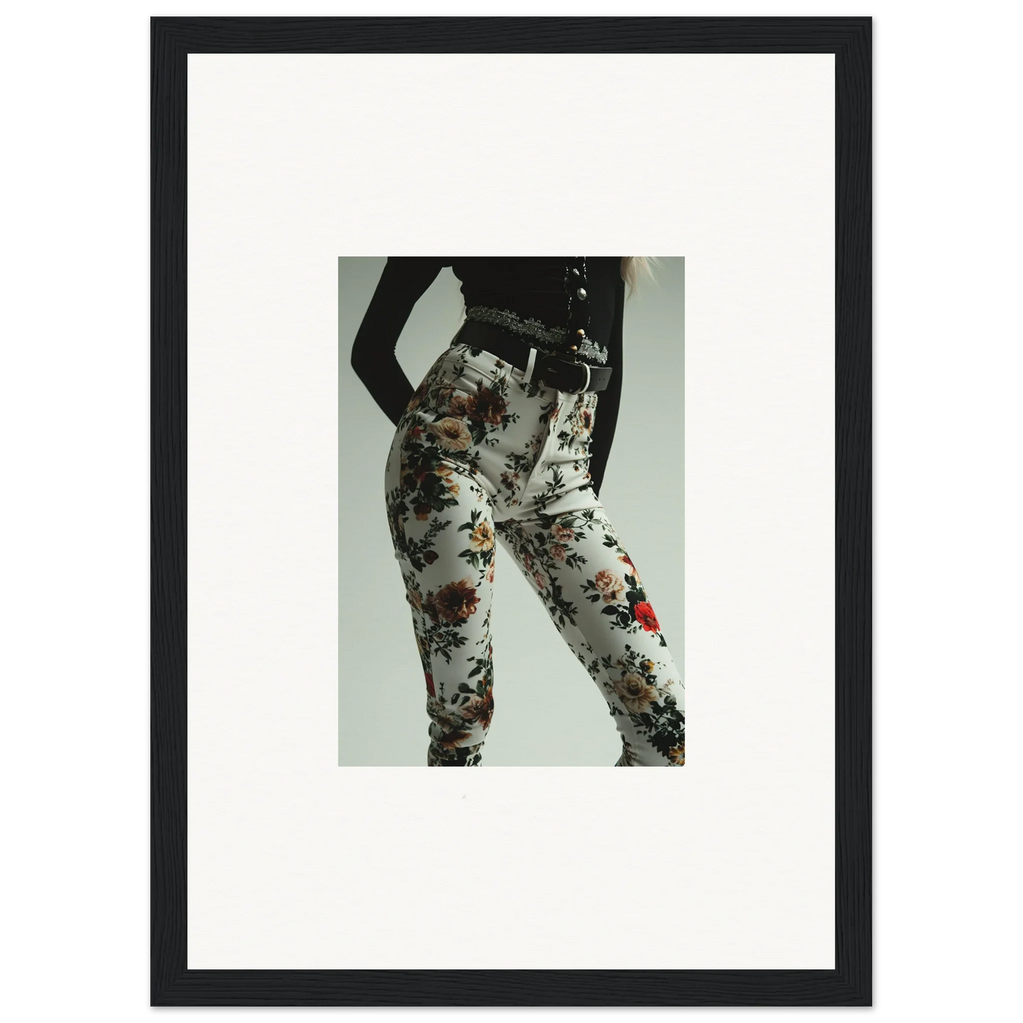 Framed black-and-white photograph of a person’s lower body wearing floral-patterned pants.