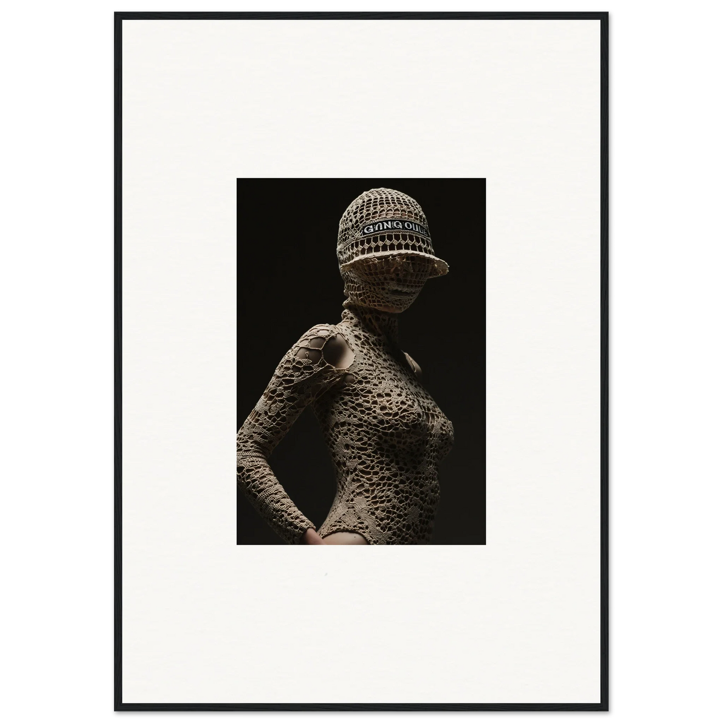 Artistic photograph of a human figure covered in a textured, scale-like pattern wearing a knitted cap.