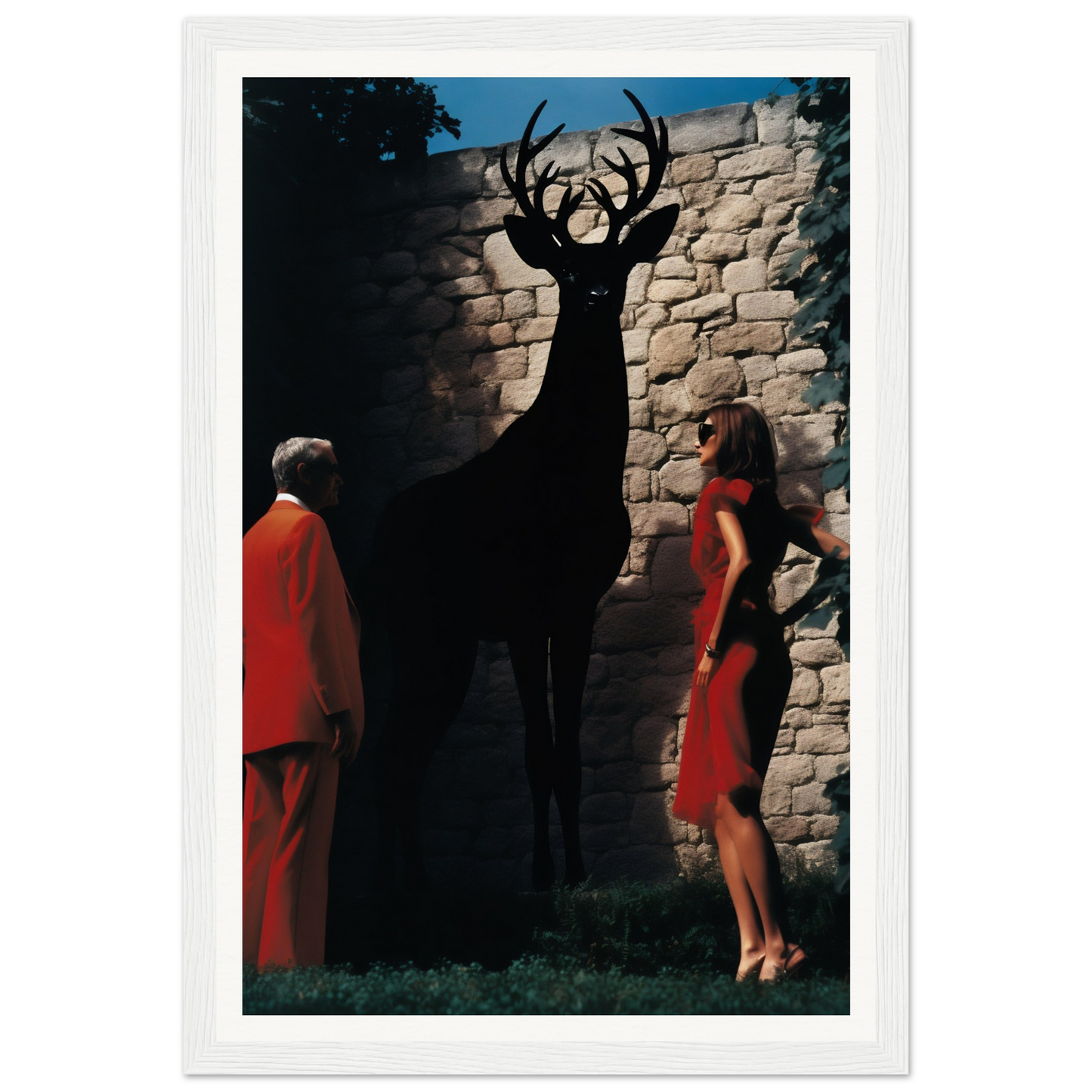 A black and white framed photograph of a woman in a red dress standing next to a deer