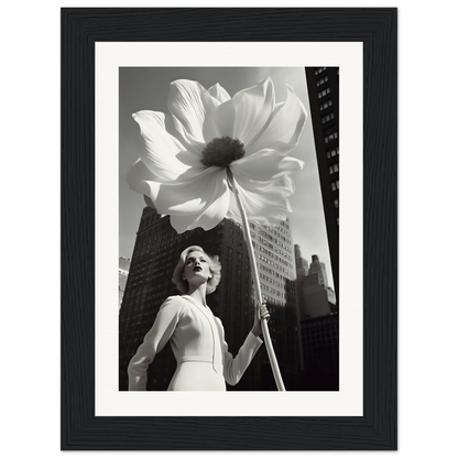 A black and white photo of a woman holding a large flower