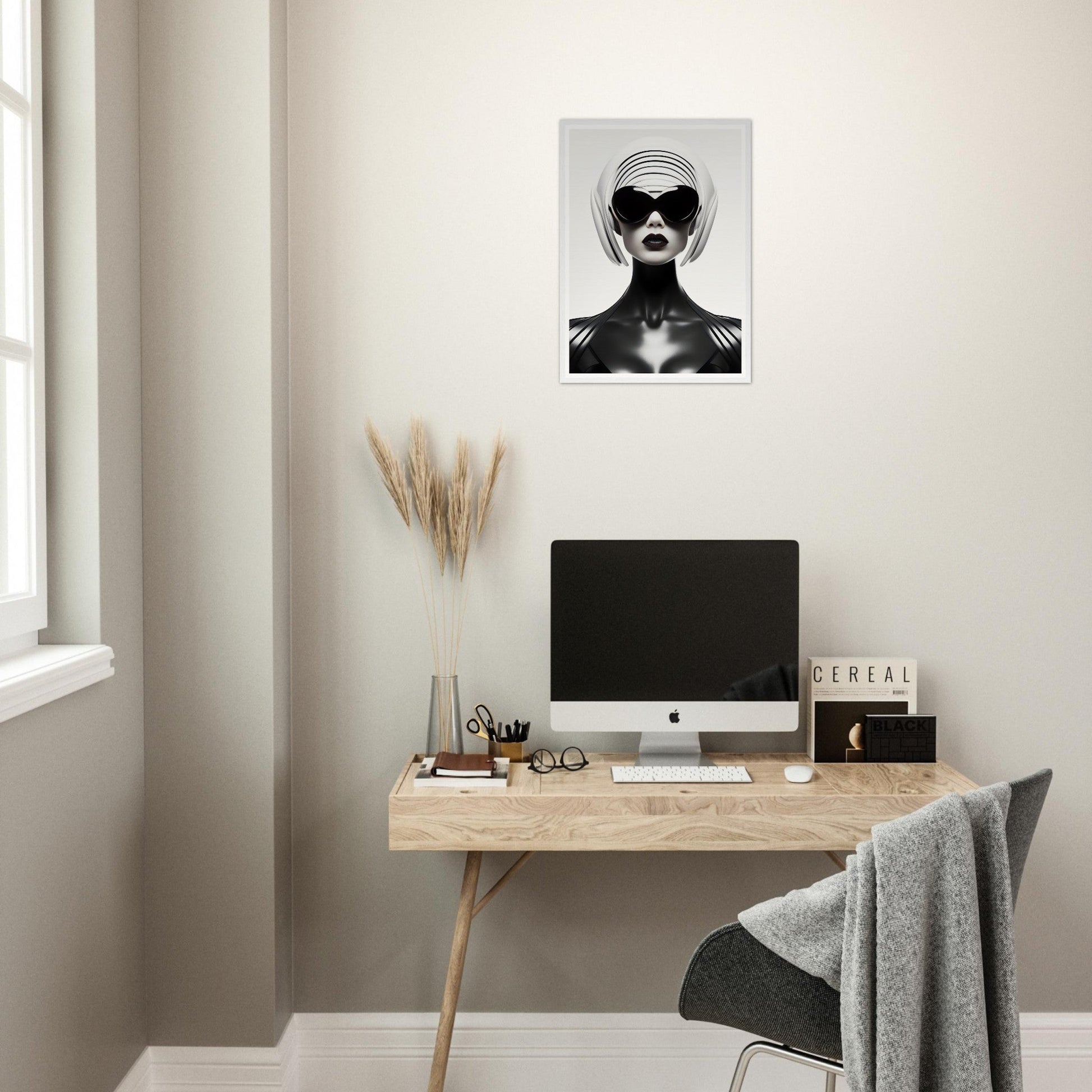 Minimalist home office workspace with a wooden desk, computer, and striking black and white portrait on the wall.