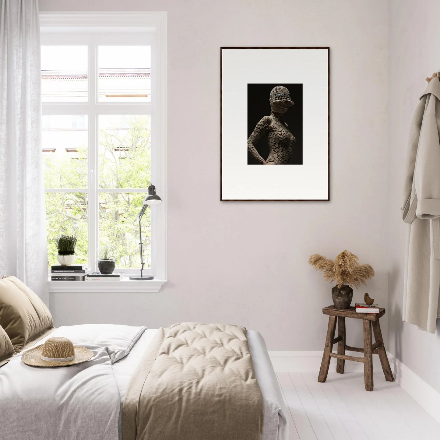 Cozy bedroom with neutral decor and a framed black and white photograph on the wall.