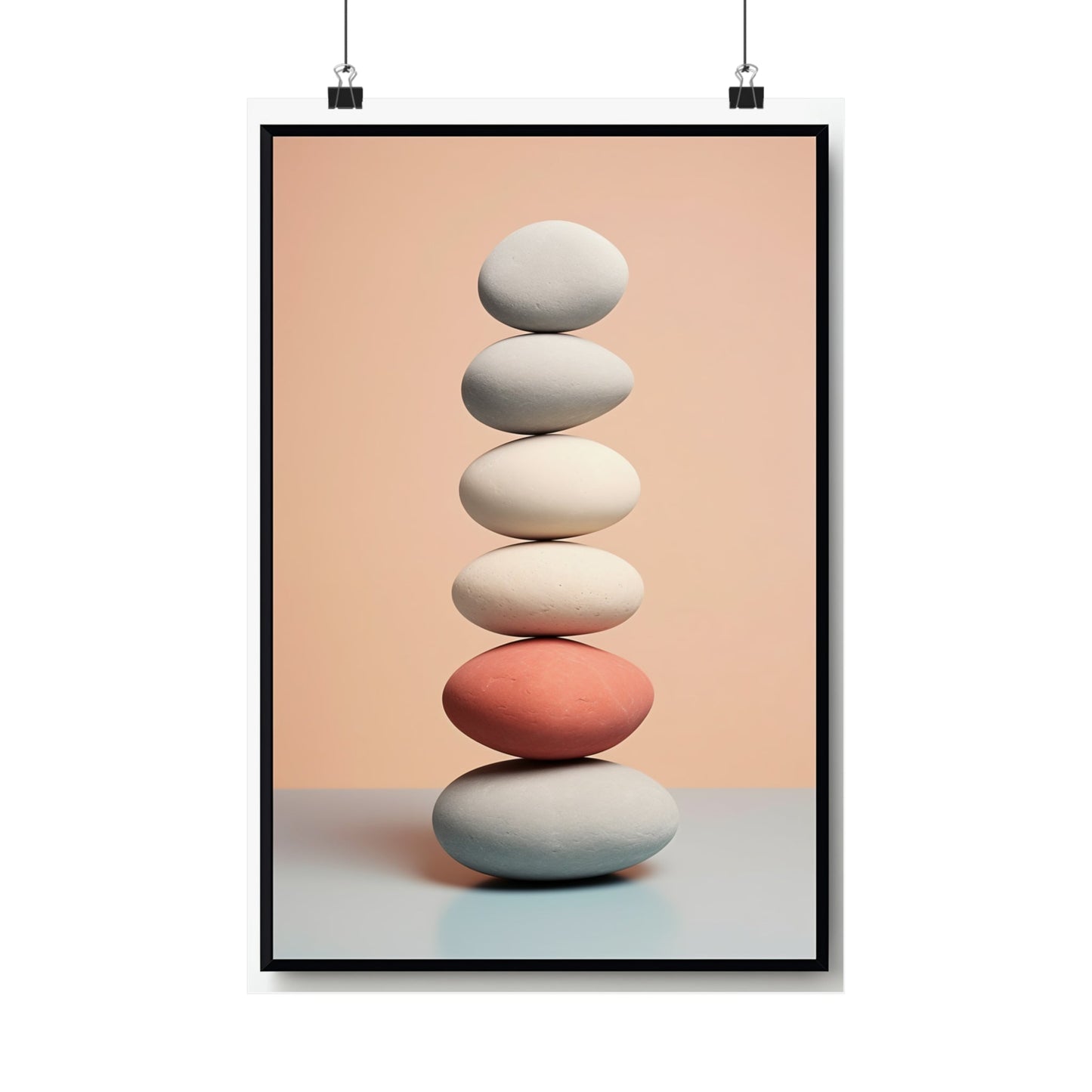 Stack of balanced stones with one coral-colored stone in the middle.