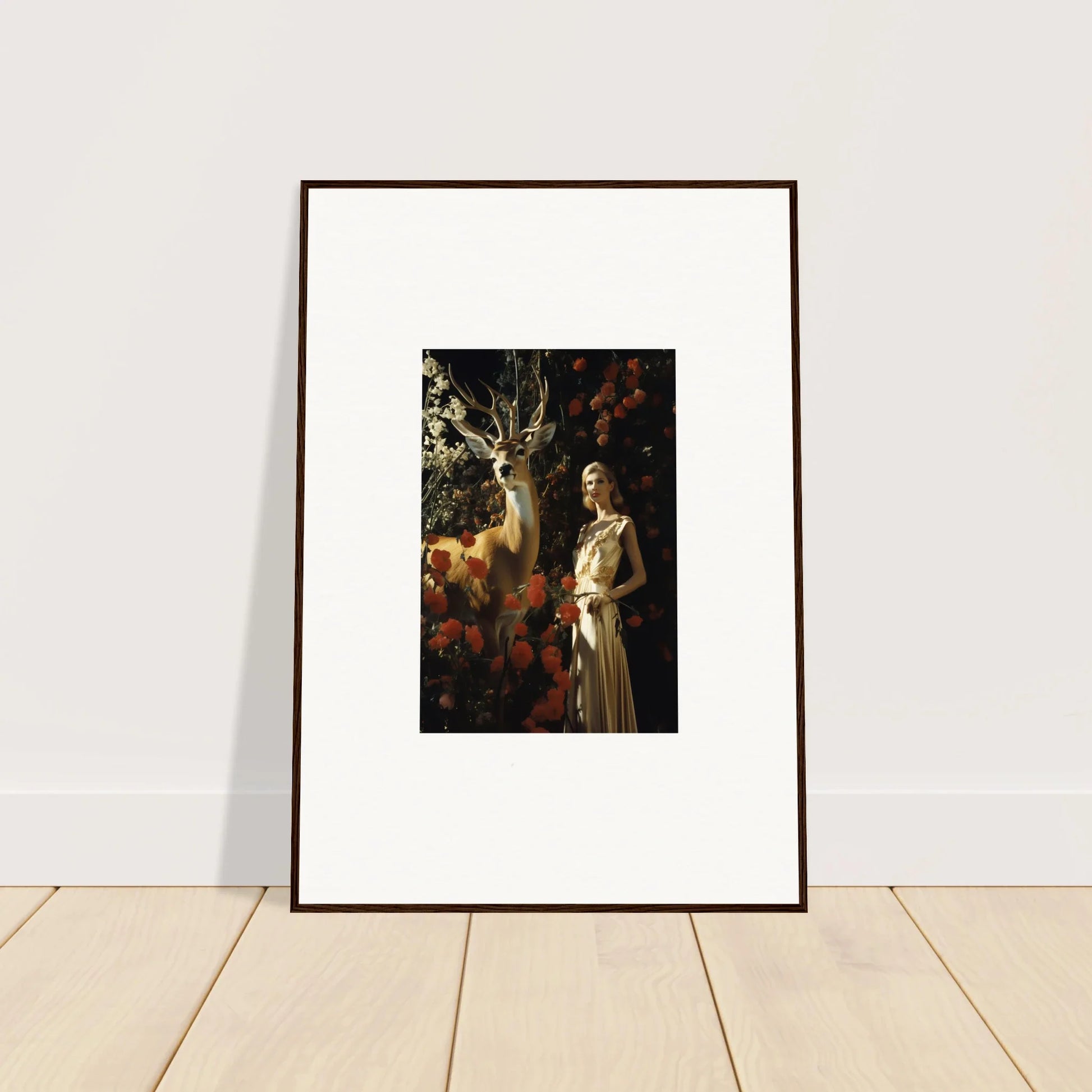 Framed artwork depicting a figure in a white dress standing next to a deer in a forest setting.