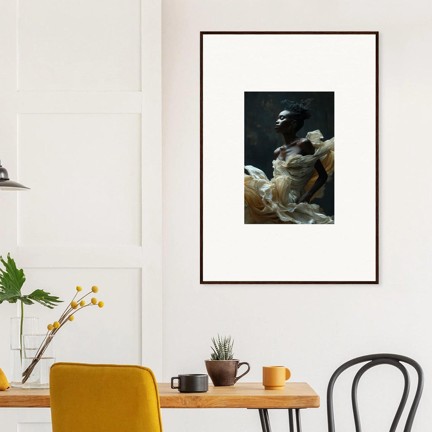 Framed black and white photograph of a person holding a baby, mounted on a white wall.