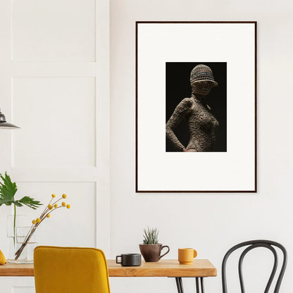 Framed black and white photograph of a figure wearing a textured garment and hat.