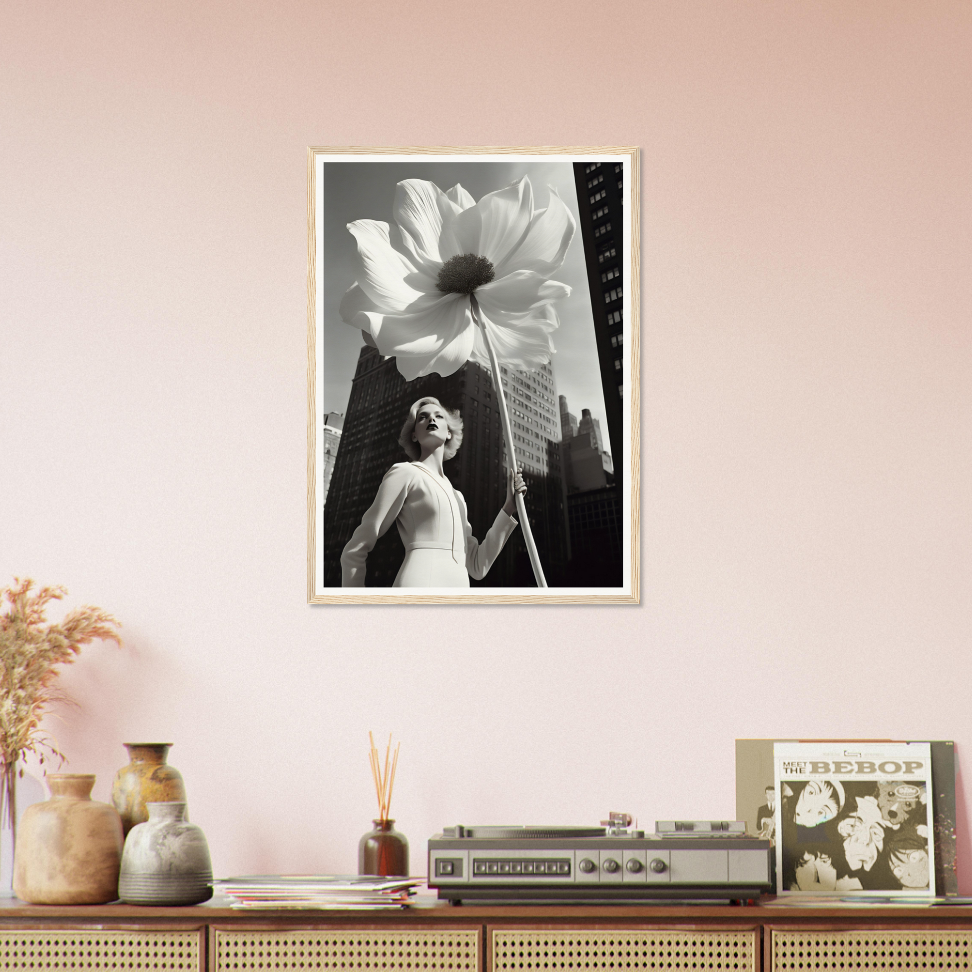 A framed print of a woman in a white dress standing in front of a pink wall