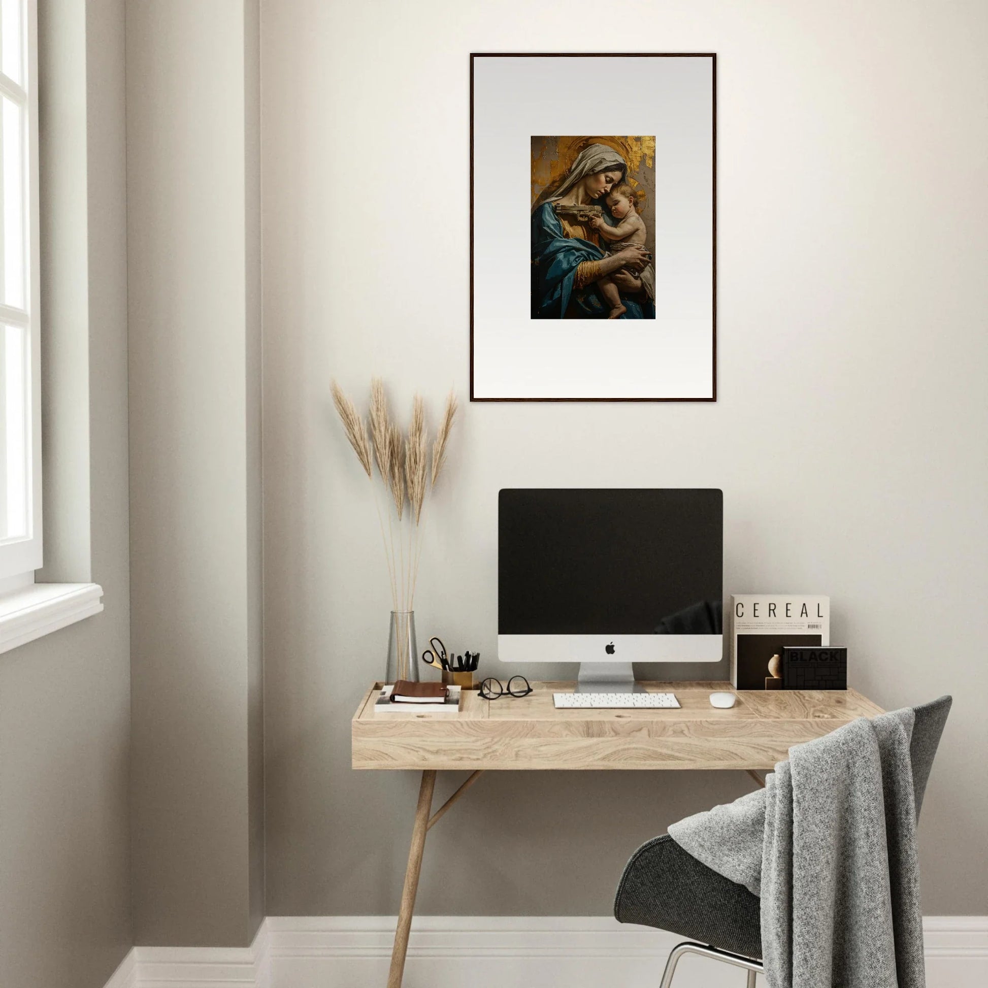 Minimalist home office with wooden desk, computer, and Saints Harmony framed wall art