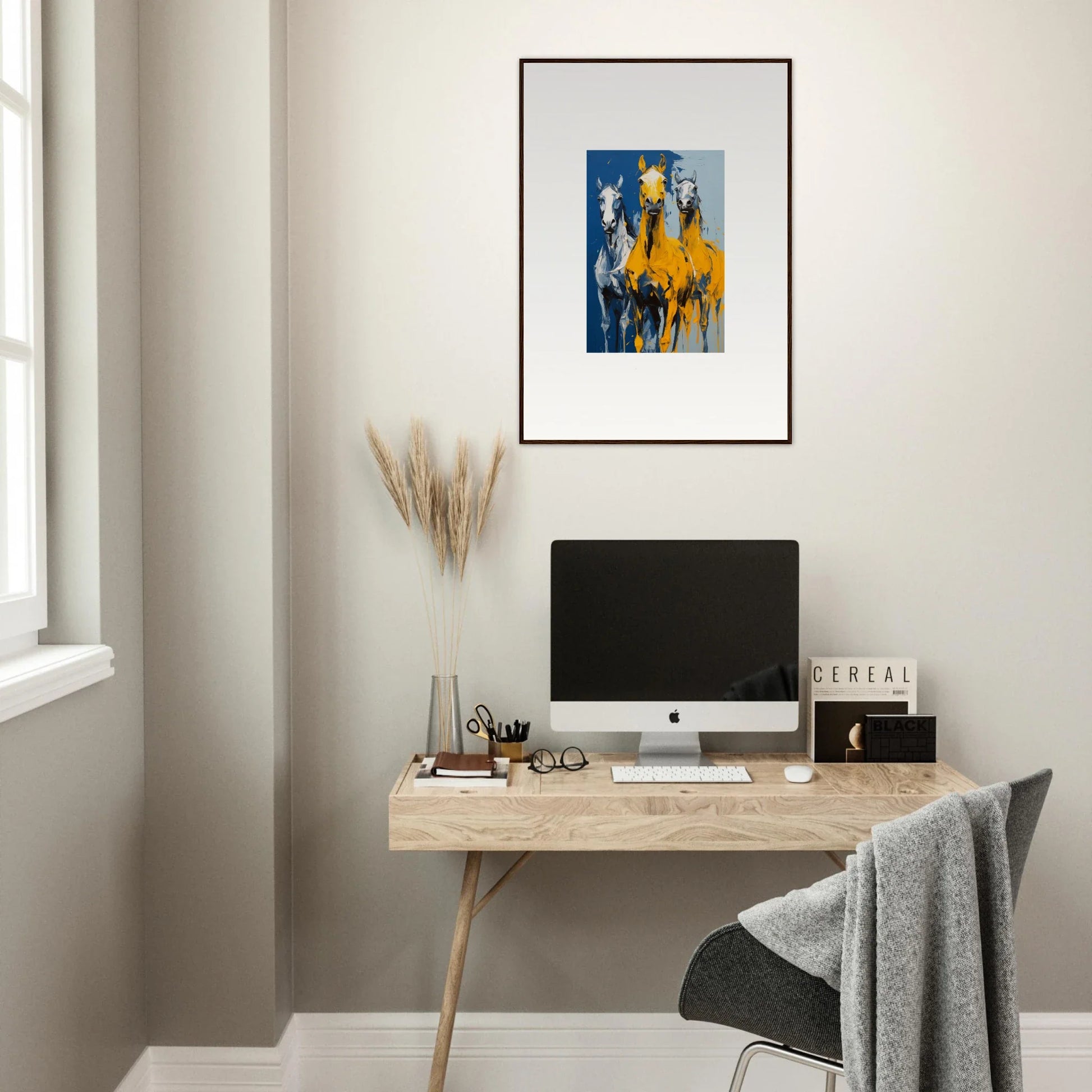 Minimalist home office with wooden desk, computer, and Eleven Sunrise framed wall art