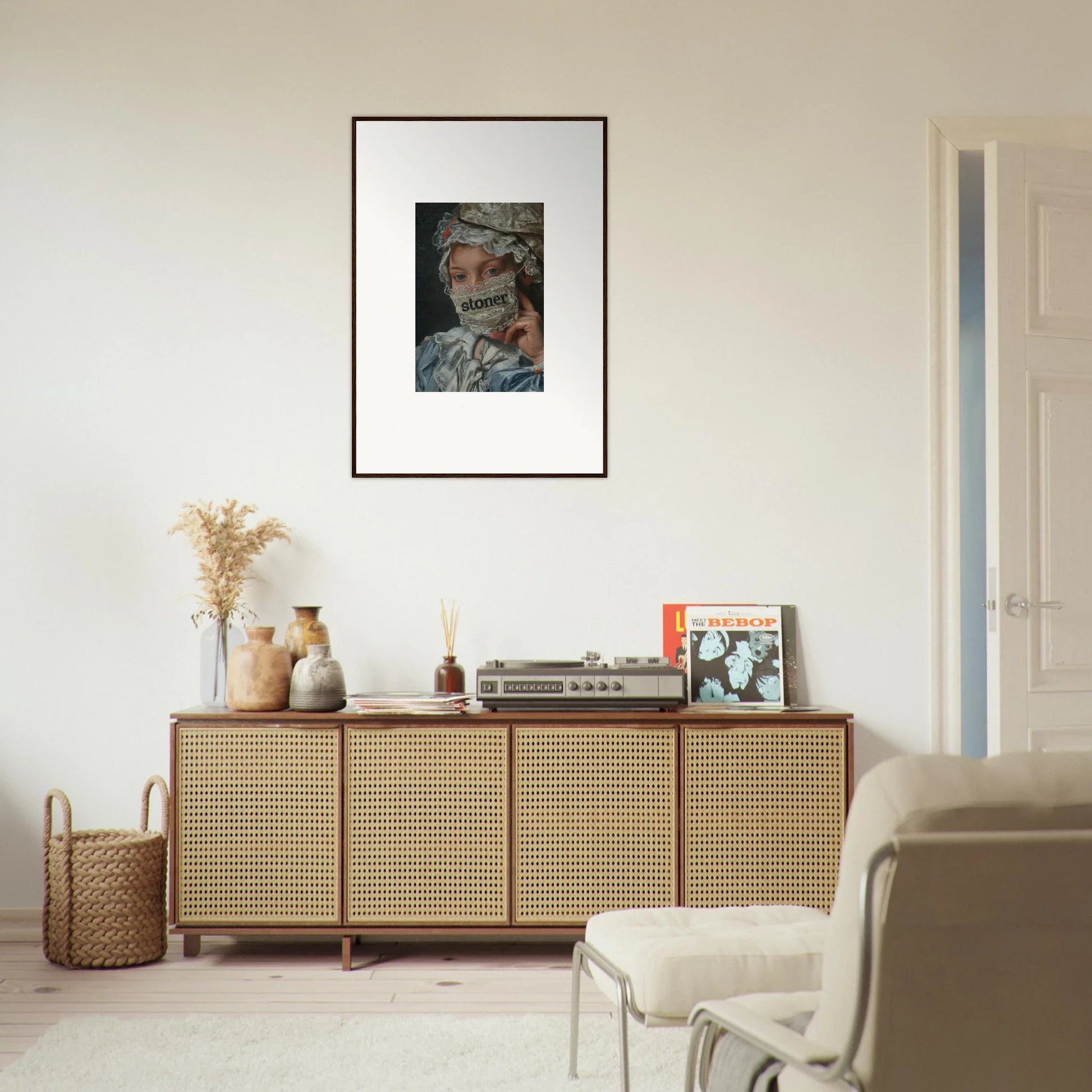 Rattan-fronted wooden sideboard with decorative items and framed wall art for Metamorphose Bliss