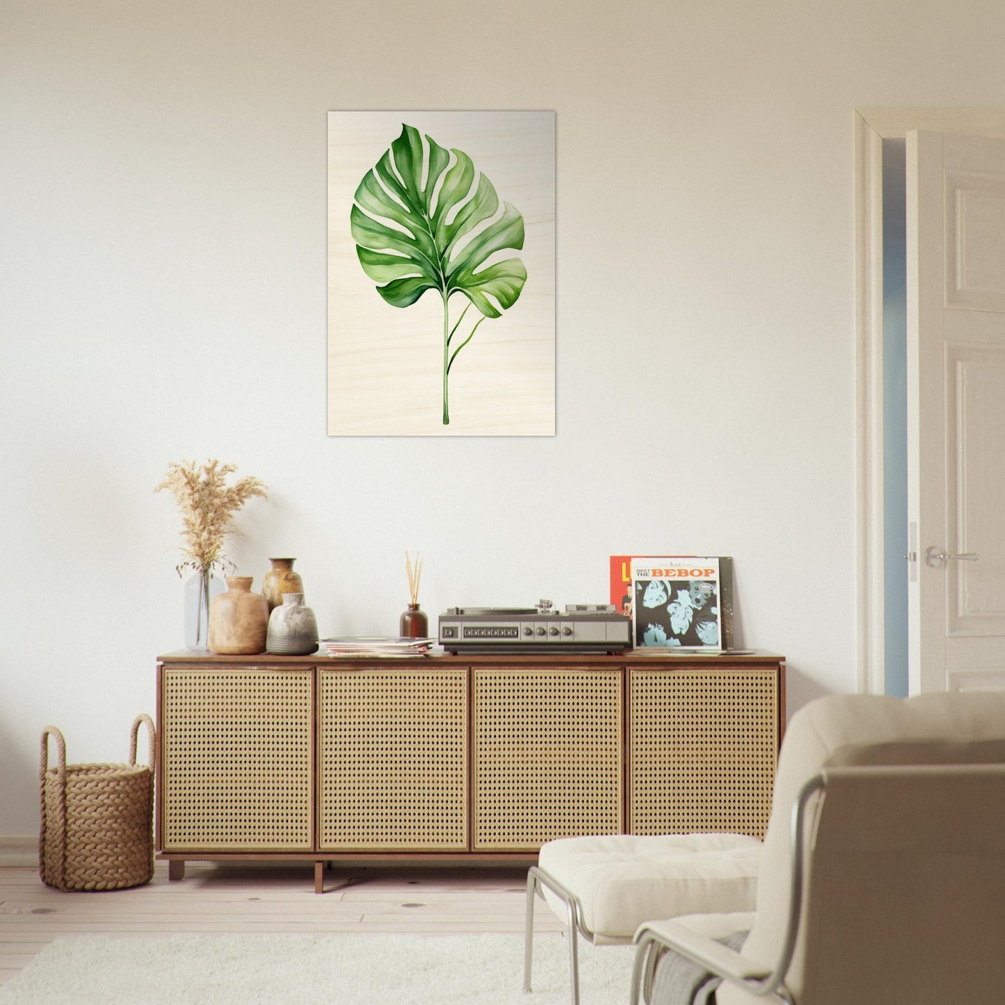 A living room with a white couch and a large green leaf on the wall