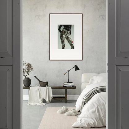 Minimalist bedroom with a framed black and white photograph on the wall.