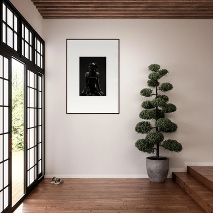 Framed black and white photograph of a person’s back on a white wall.