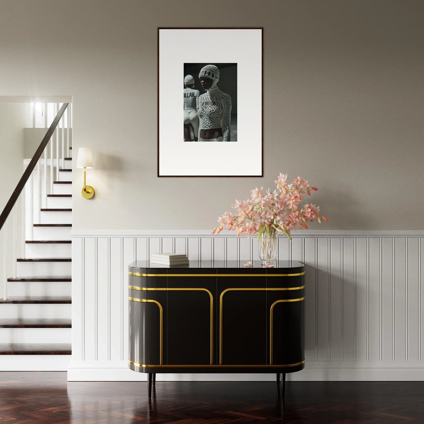 Elegant black and gold sideboard with curved edges beneath a framed photograph and floral arrangement.