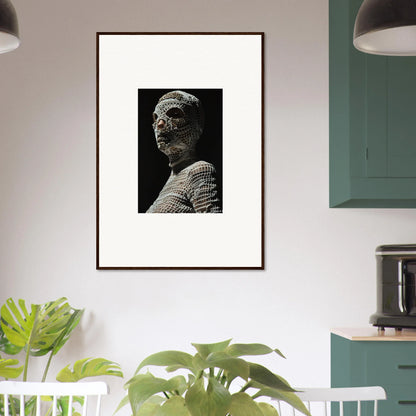 Framed black and white photograph of an ancient stone sculpture depicting a human figure.