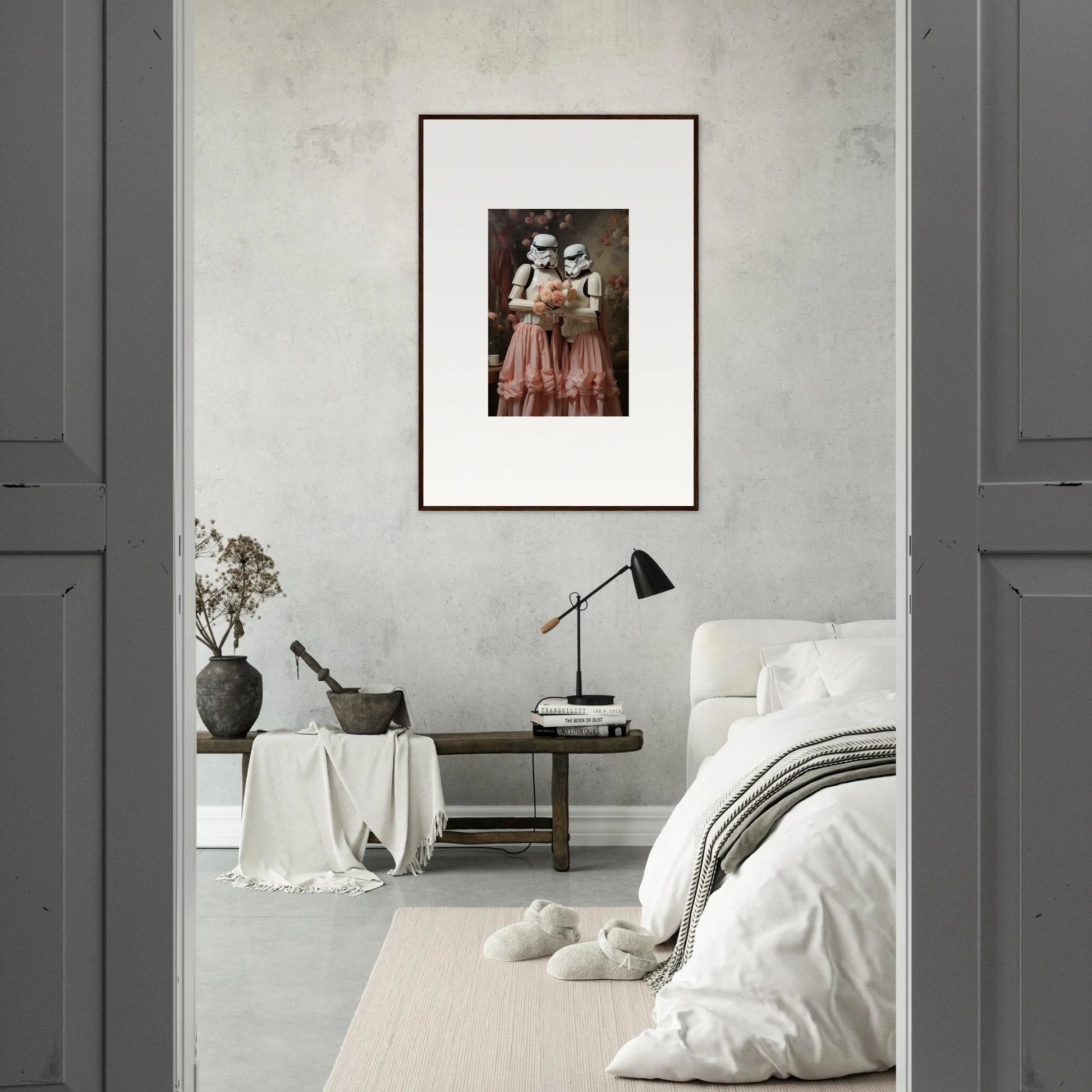 Framed vintage photograph of two figures in period dress hanging on a white wall.