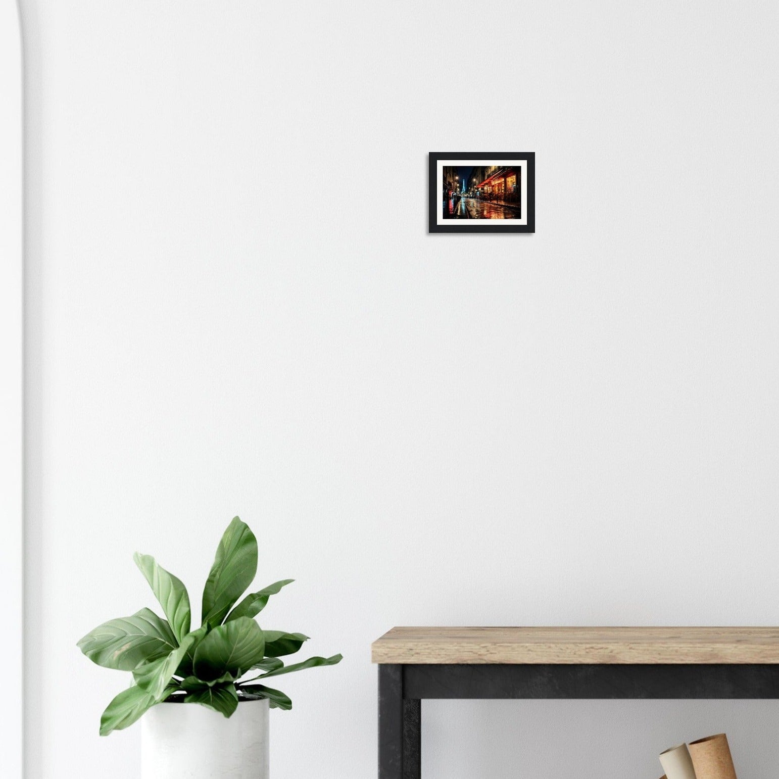 Framed photograph of a nighttime urban street scene hanging on a white wall.