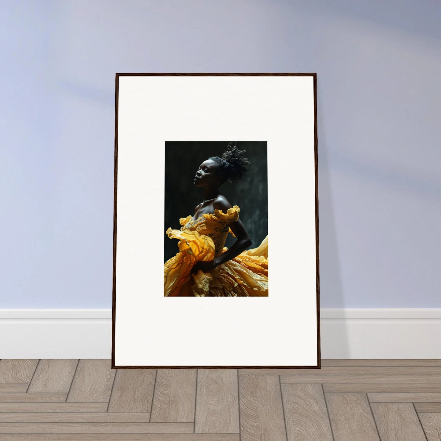 Framed artwork depicting a person wearing vibrant yellow-orange fabric against a dark background.