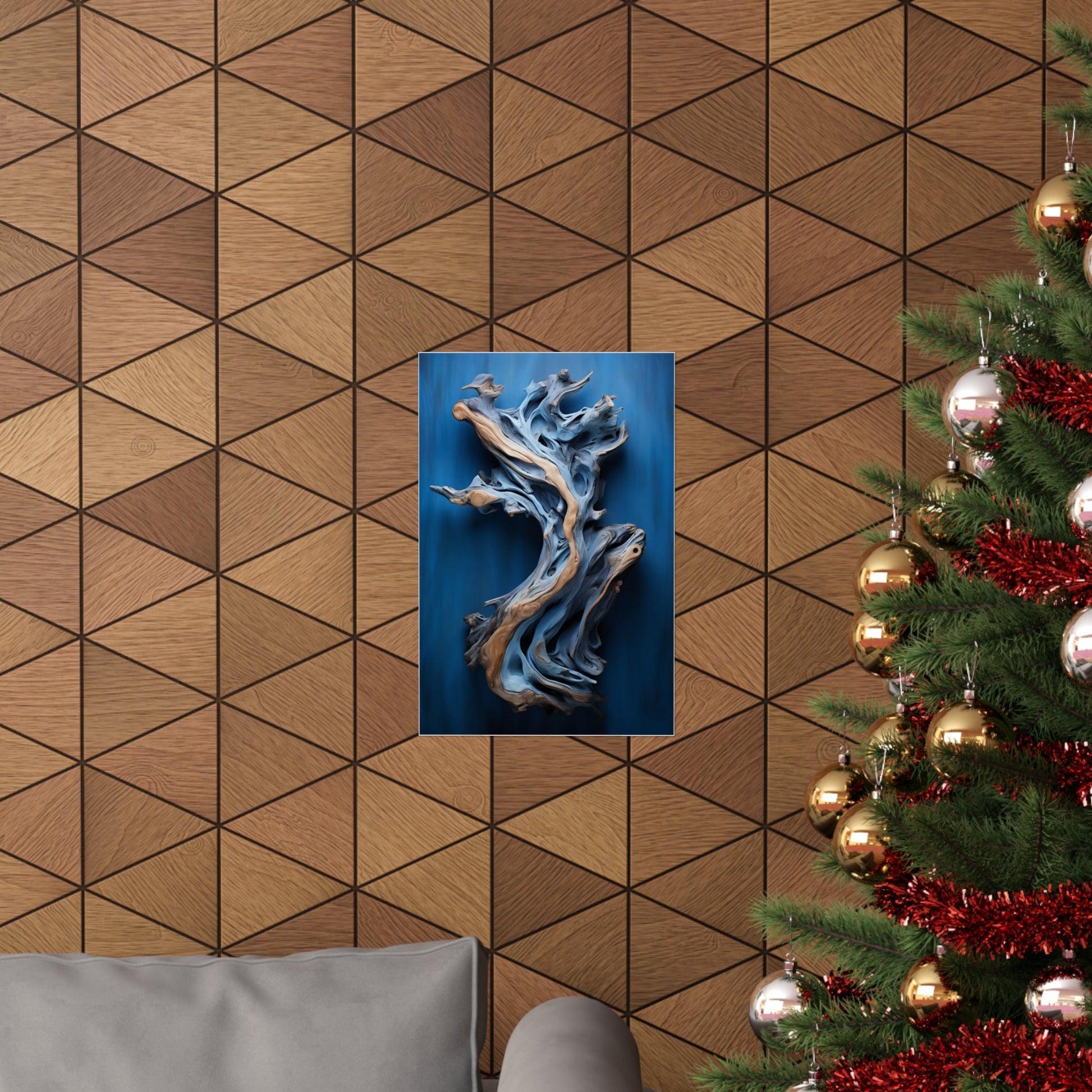 Abstract metallic sculpture with flowing, organic forms mounted on a blue background.