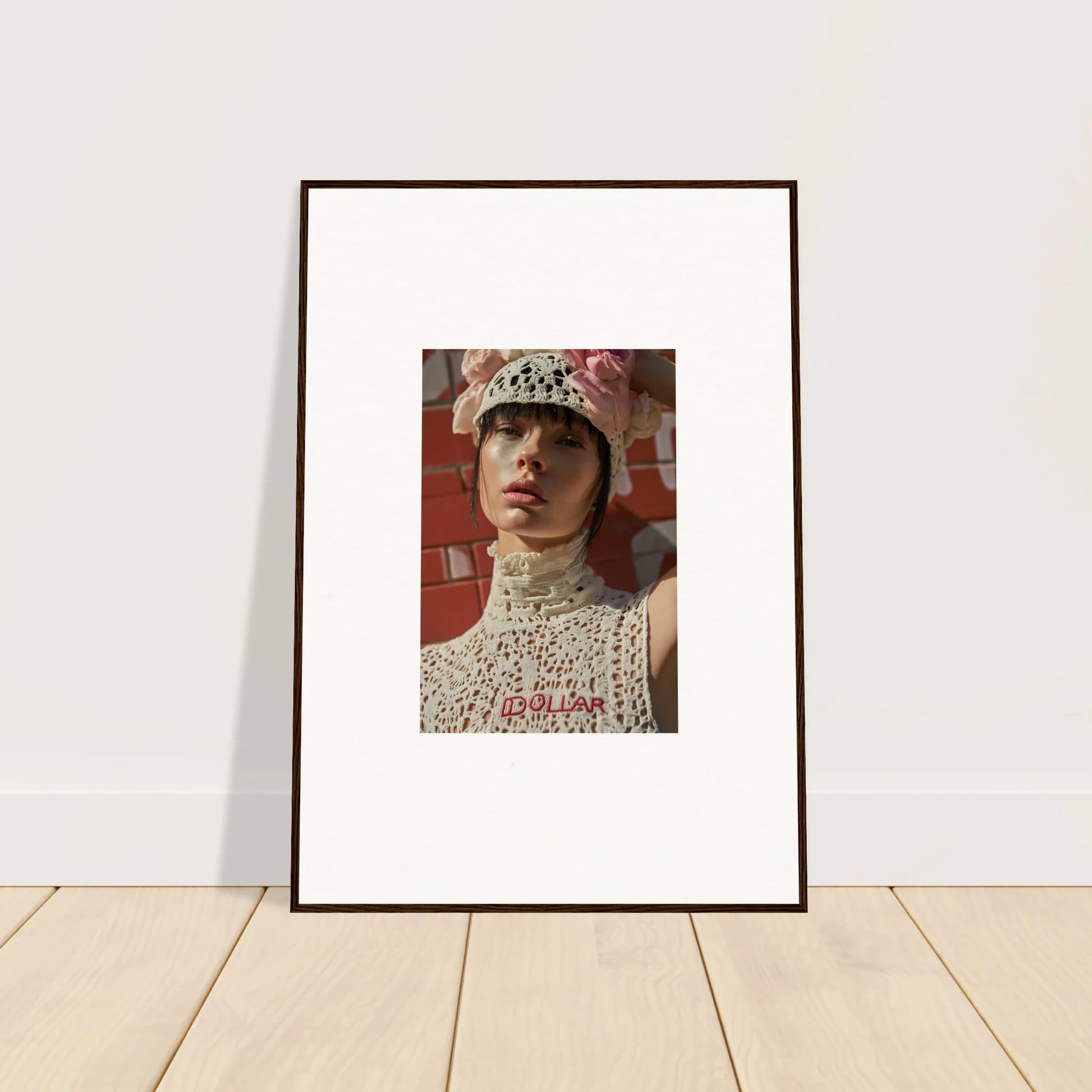 Framed portrait photograph of a person wearing a white lace top and floral hat.