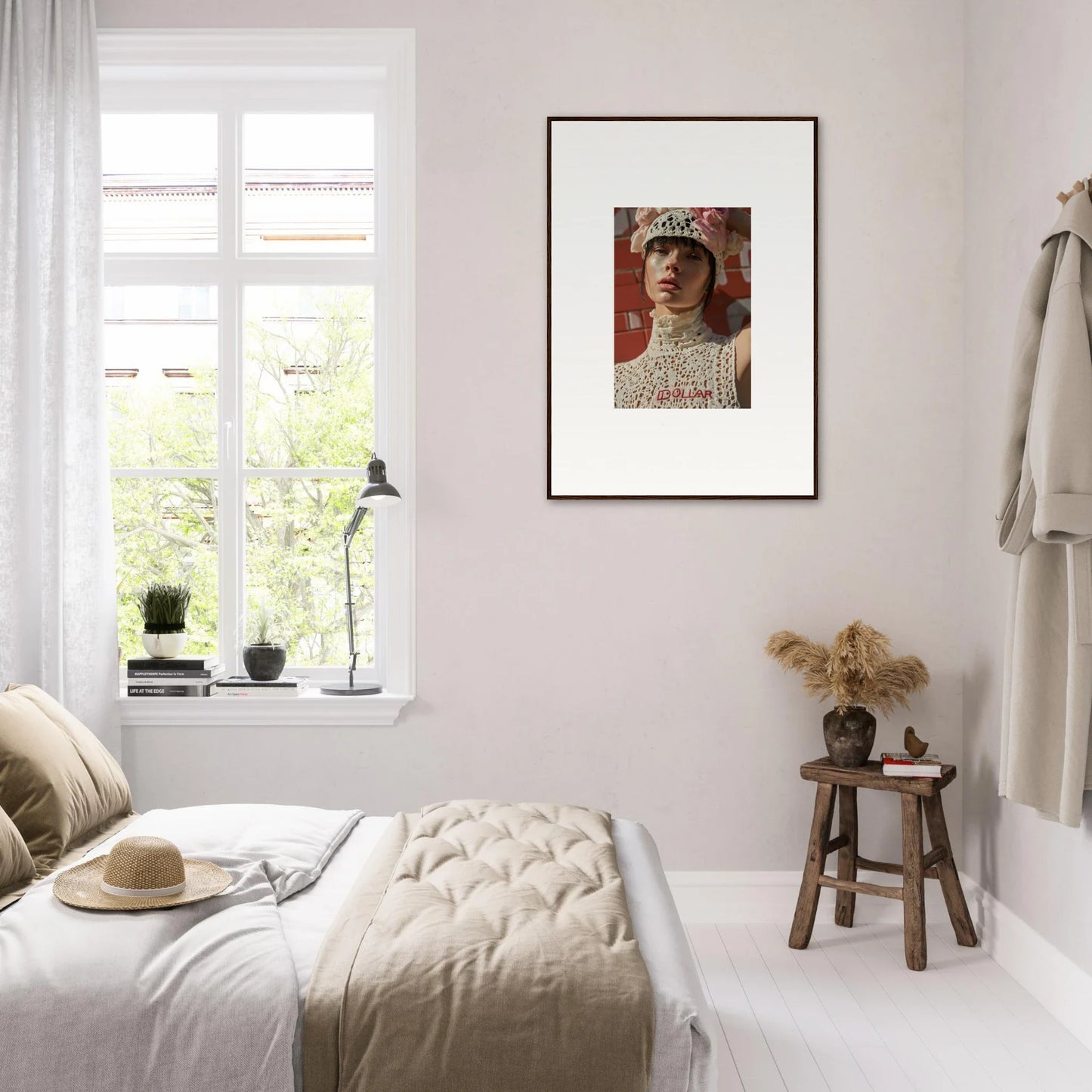 Cozy bedroom with neutral decor and a framed portrait on the wall.