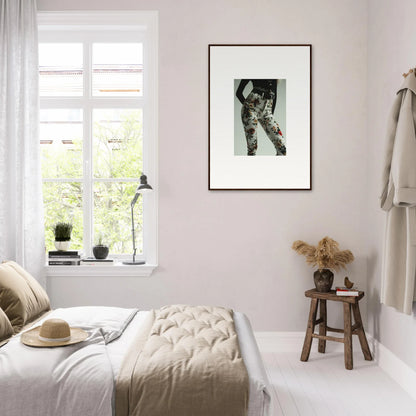 Bright, minimalist bedroom with a framed black and white photograph on the wall.