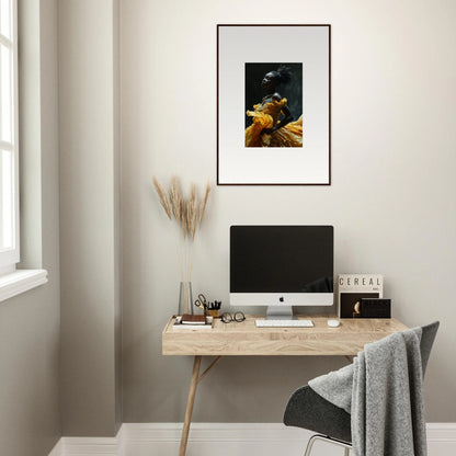 Minimalist home office workspace with a wooden desk, computer, and framed artwork.