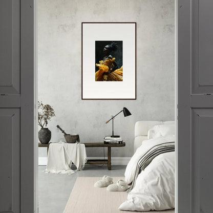 Framed artwork featuring a dark figure wearing a yellow garment against a black background.