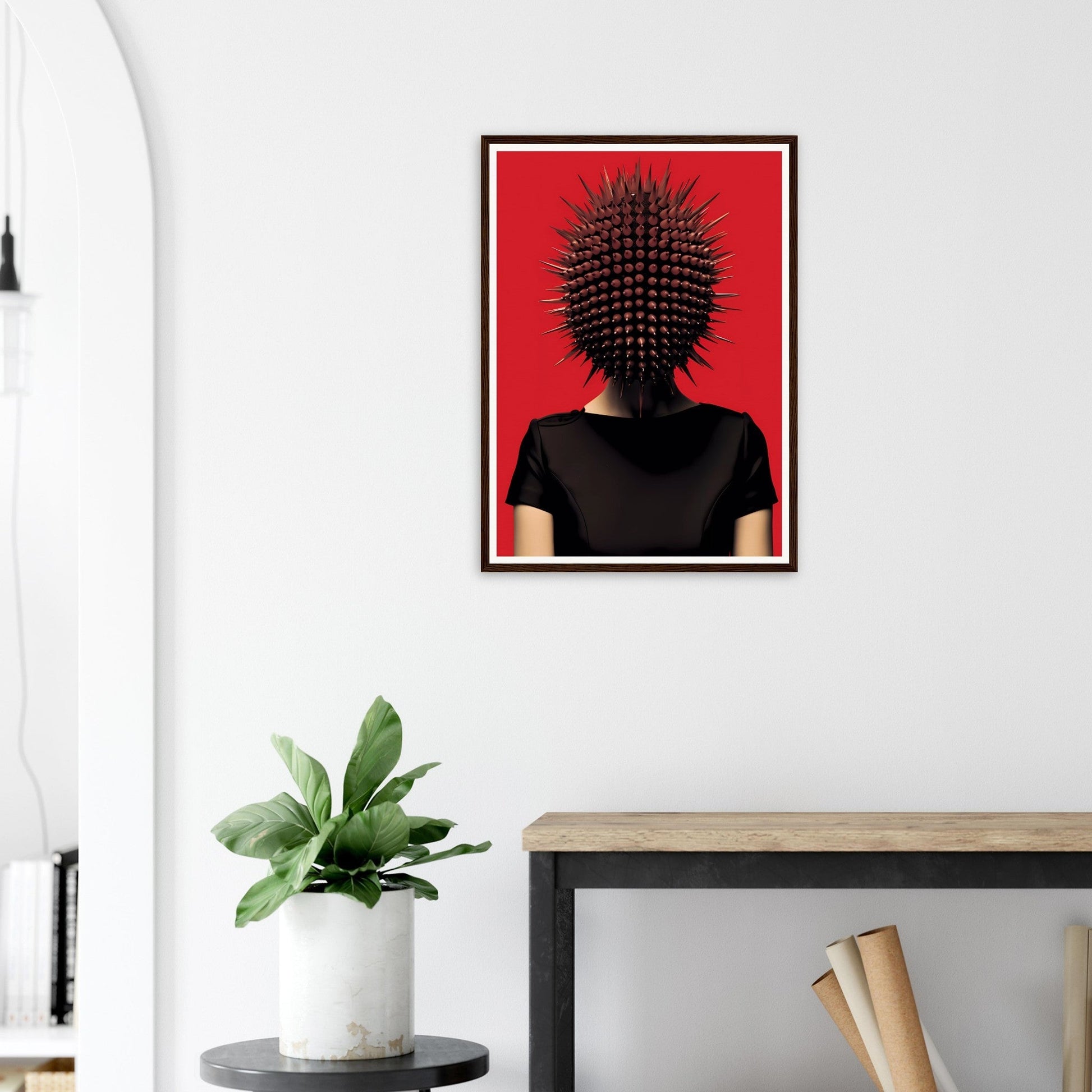 Framed surrealist portrait featuring a figure with a spiky, spherical head against a vivid red background.