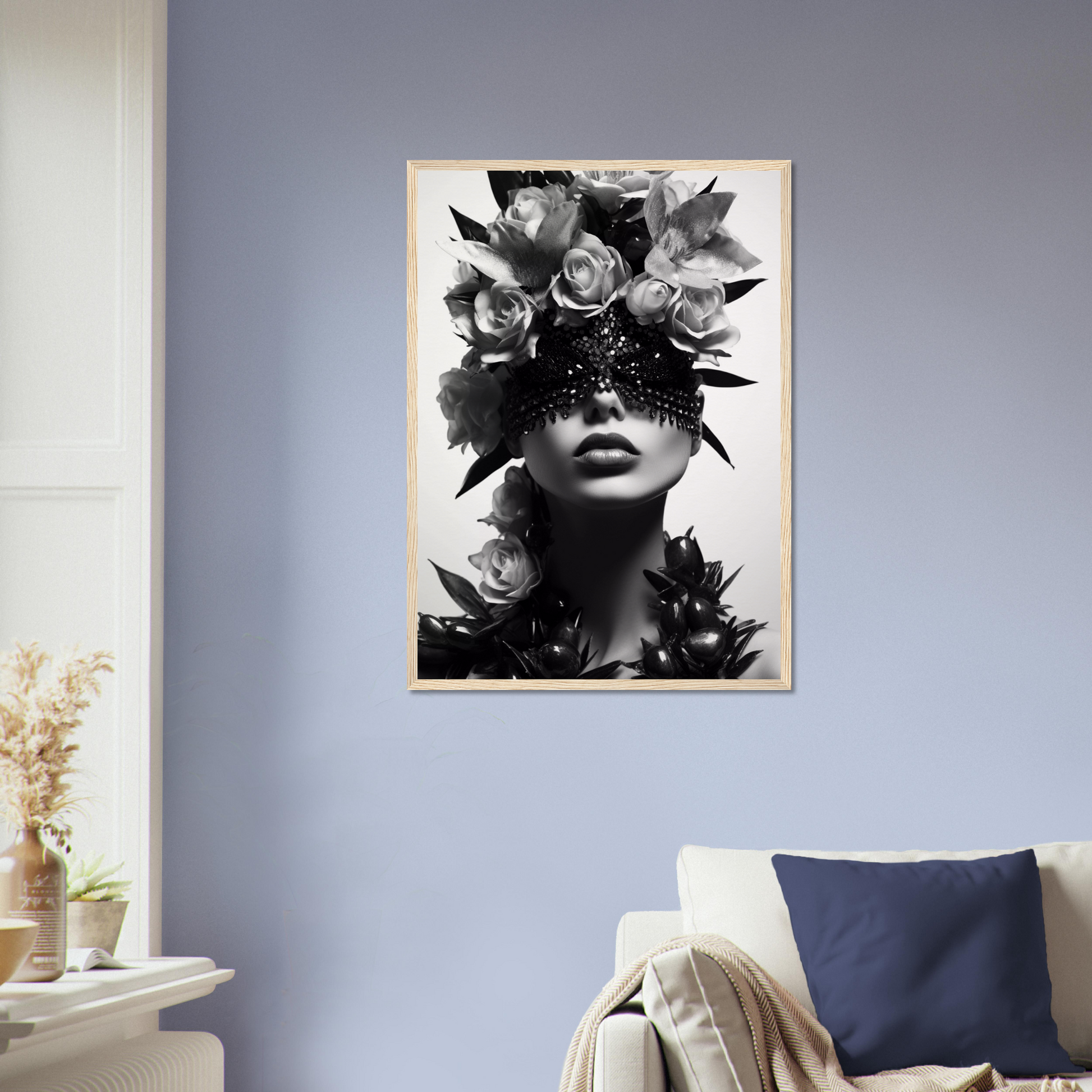 Framed black and white portrait of a figure adorned with floral headpiece and ornate eye covering.