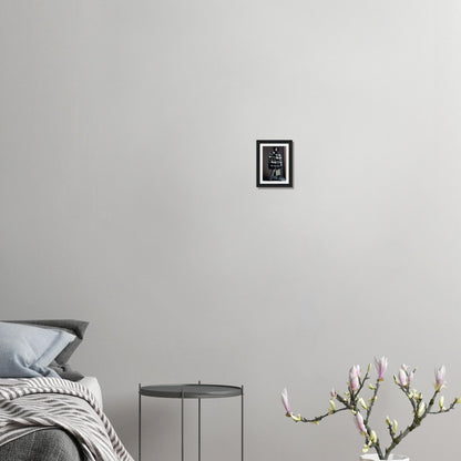 Minimalist bedroom corner with a bed, side table, and decorative plant branch.